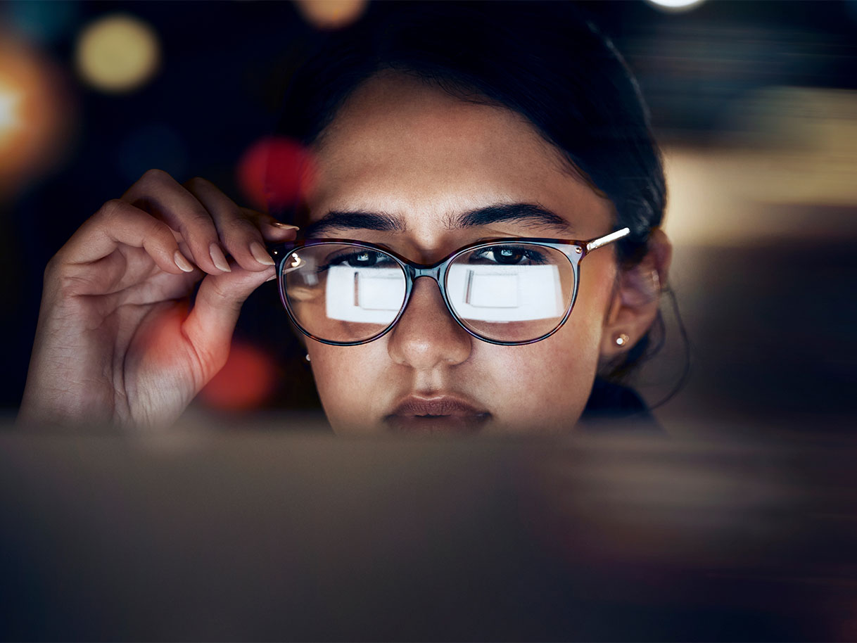 computer screen reflected in woman's glasses