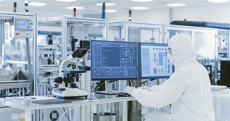 Lab technician looking at data on a computer screen