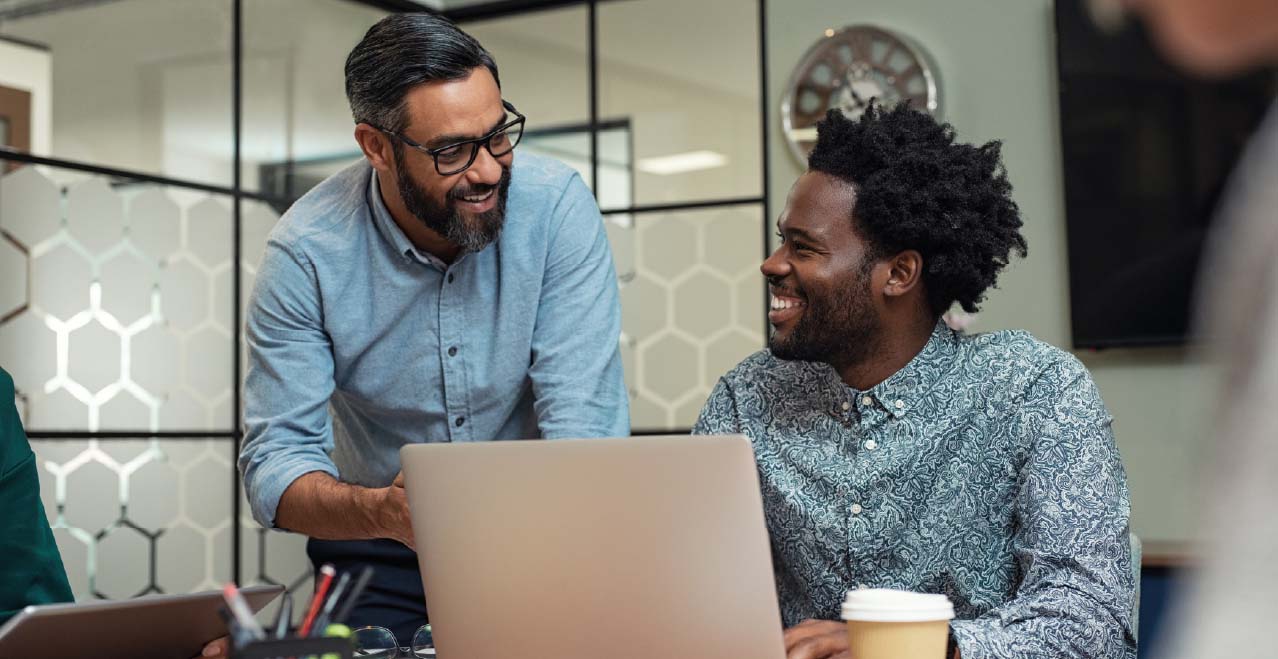 Workers discussing content on a computer screen